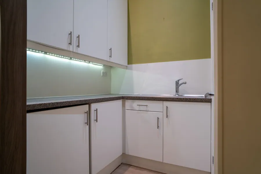 Kitchenette with sink and cupboards